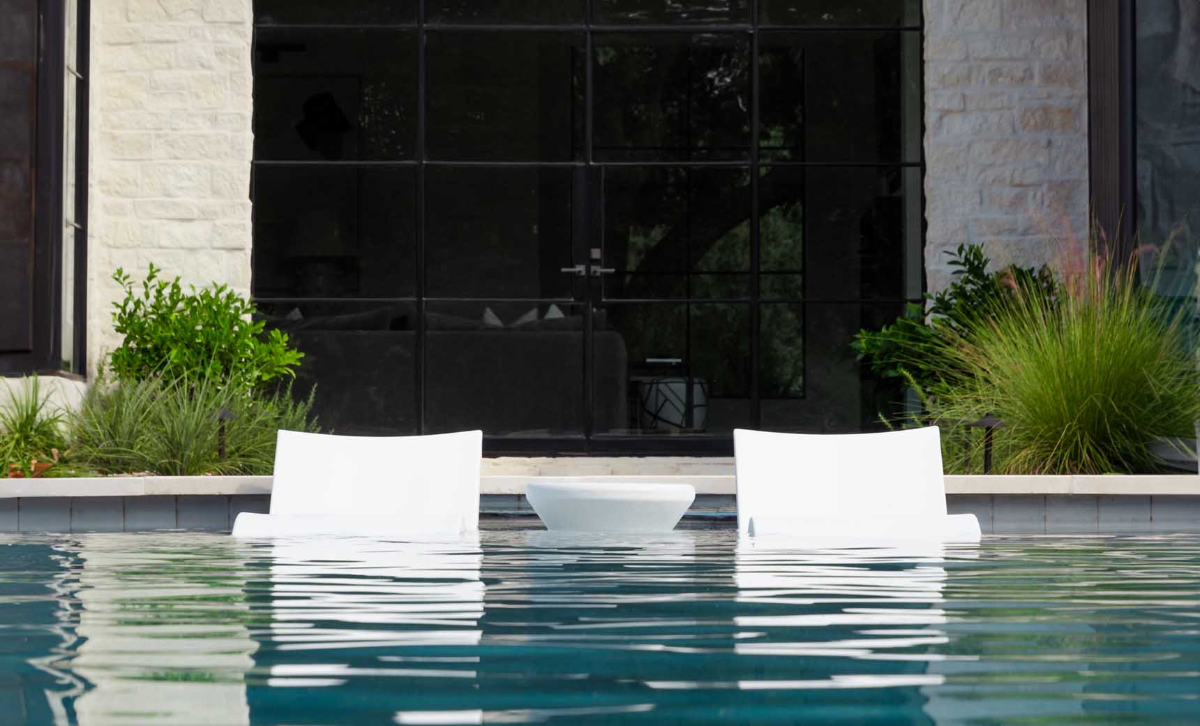 Signature chaise lounge in a modern design paired with a sleek side table for an in-pool setup.