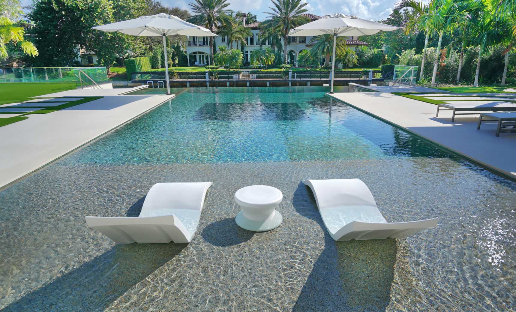 Signature chaise lounge in a modern design paired with a sleek side table for an in-pool setup.