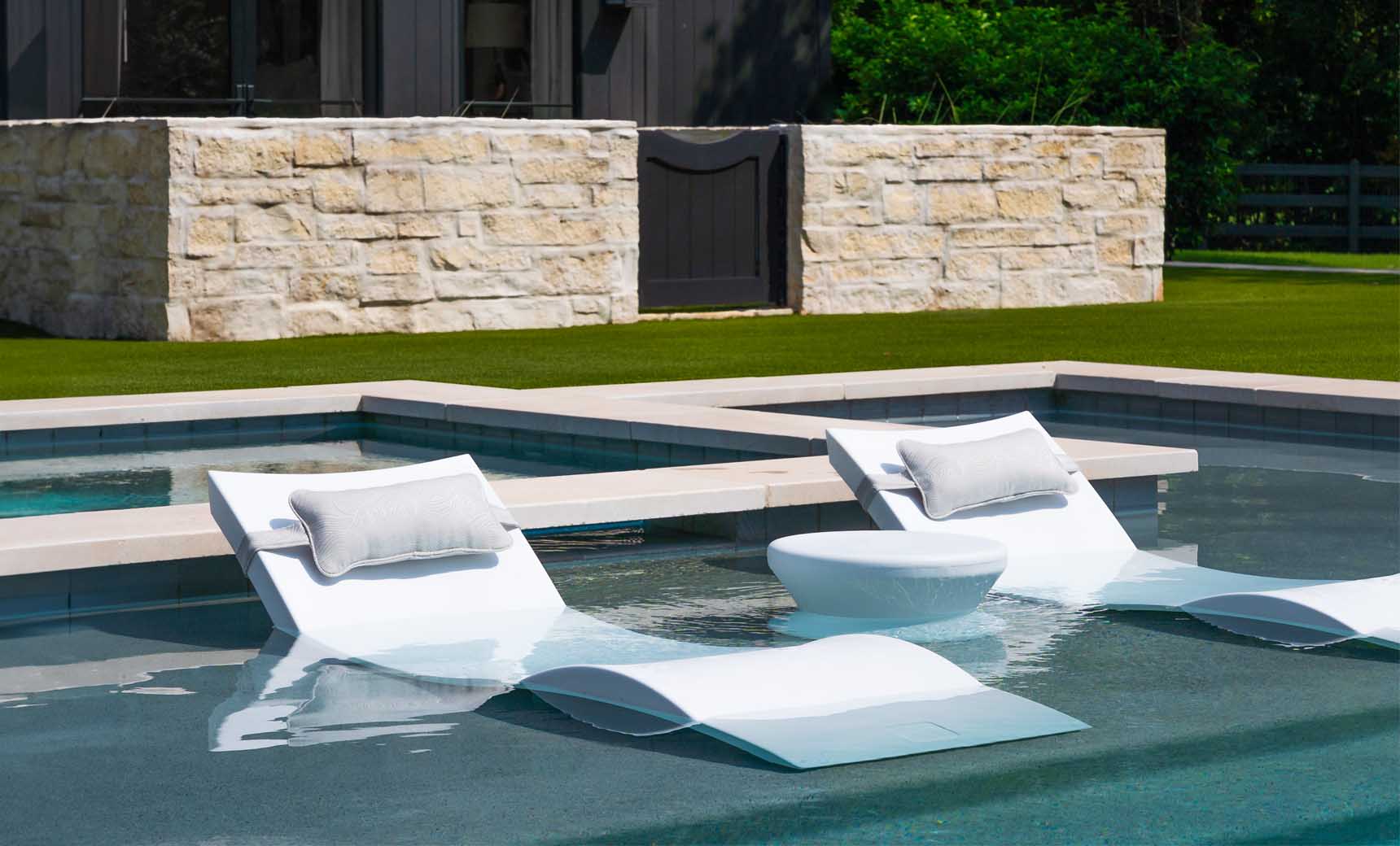 Signature chaise headrest pillow paired with a side table for in-pool use.