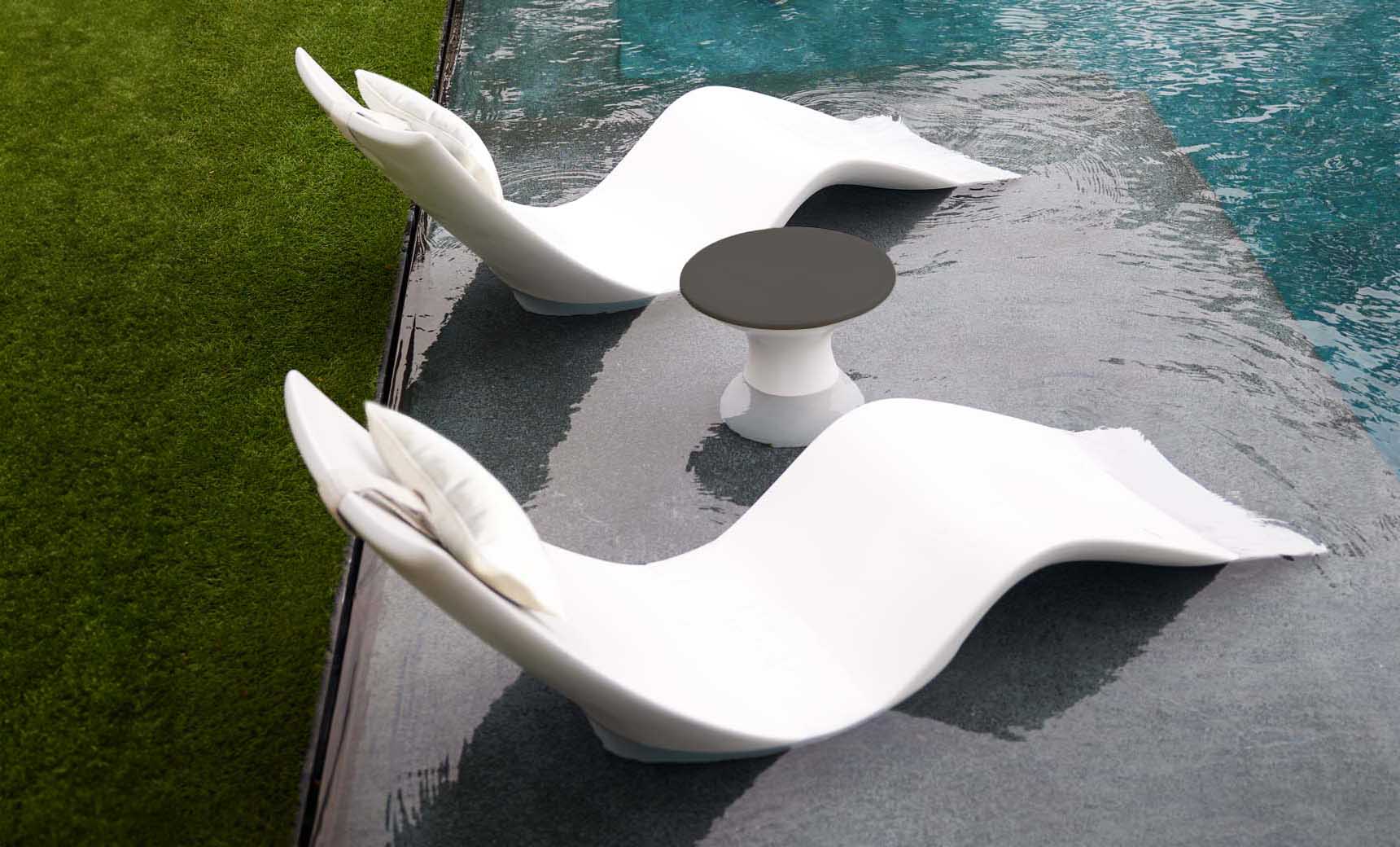 Autograph chaise lounge chair paired with a matching side table designed for poolside use.