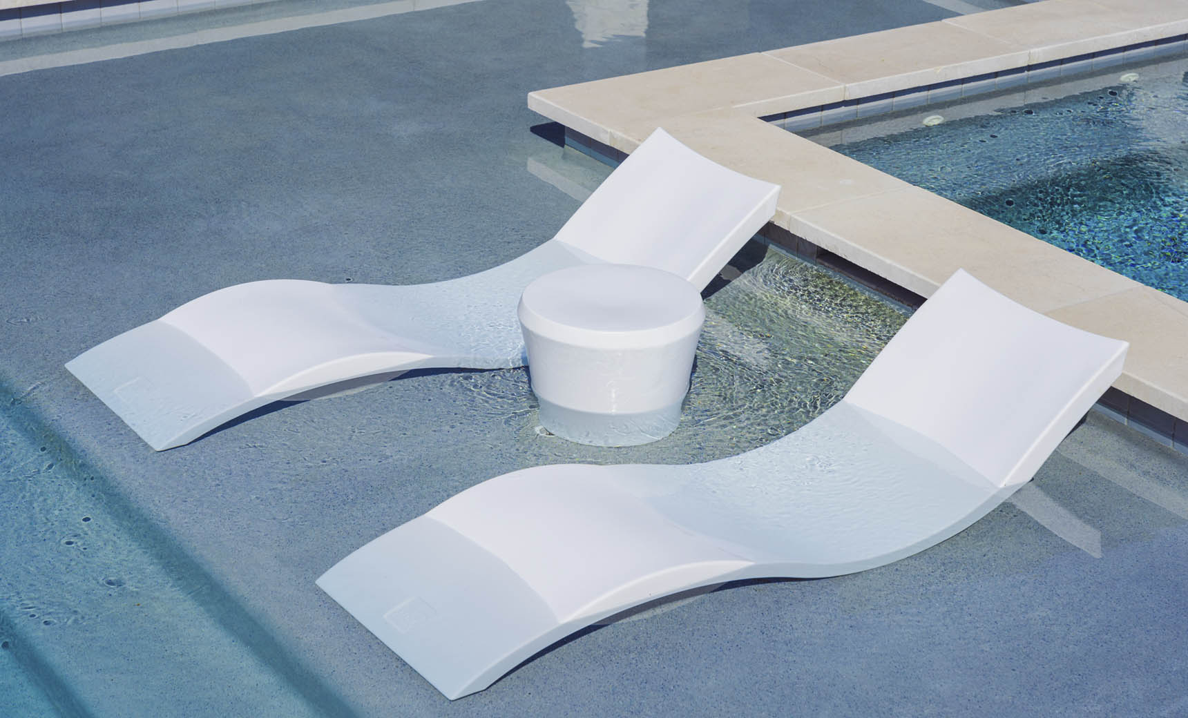 Signature chaise lounge with black frame and gray cushion paired with an Affinity side table in a pool setting.