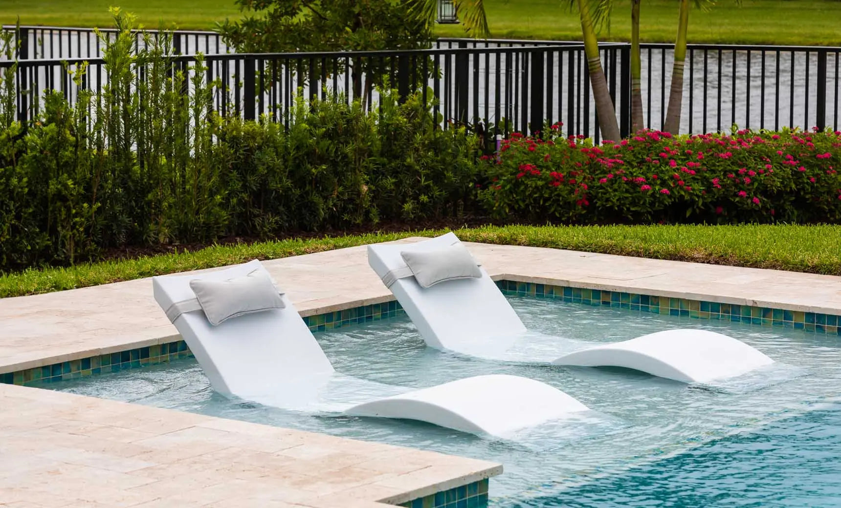 Signature pool chaise lounge with matching headrest pillow in vibrant blue fabric