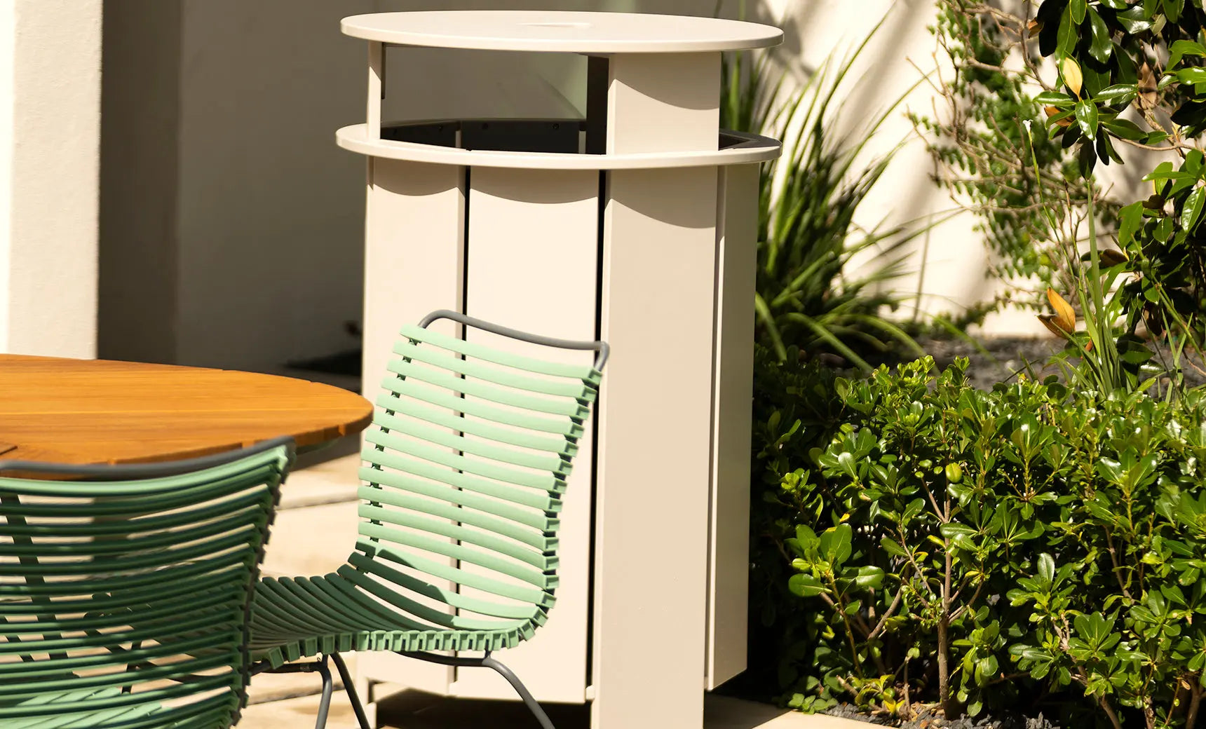 Mainstay gray trash bin with a lid and four wheels for easy mobility.