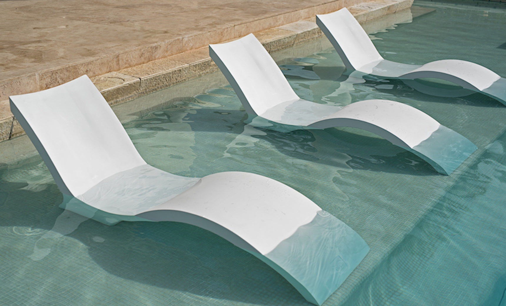 Signature Chaise lounge in pool with matching deep cushion and side table for relaxation.
