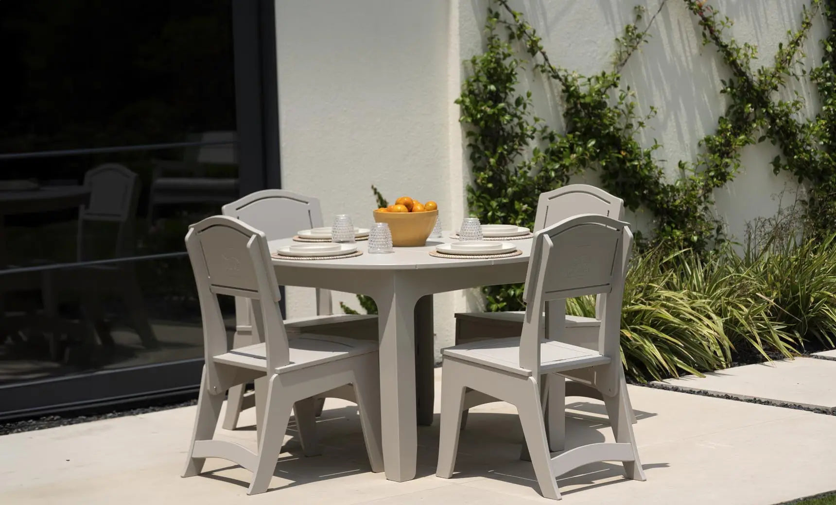 Round dining table made of wood with a smooth surface and four legs.