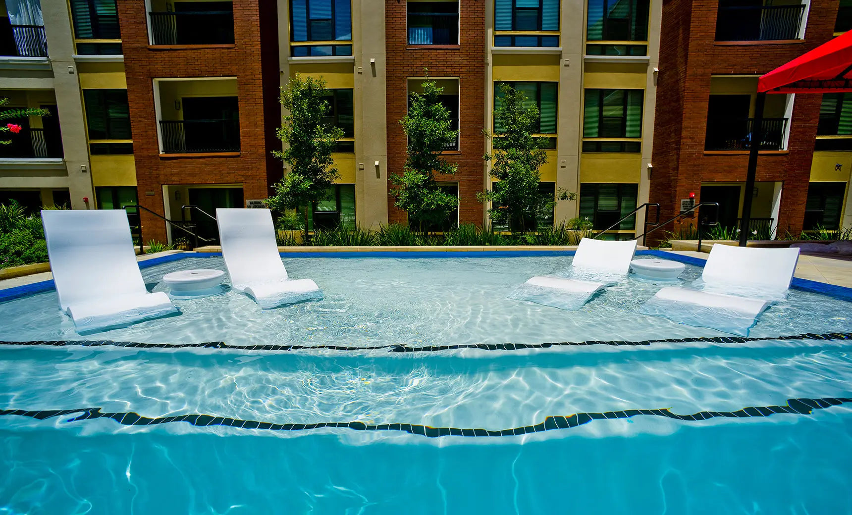 Signature pool chaise lounge set with two matching chairs and a side table in a modern design.