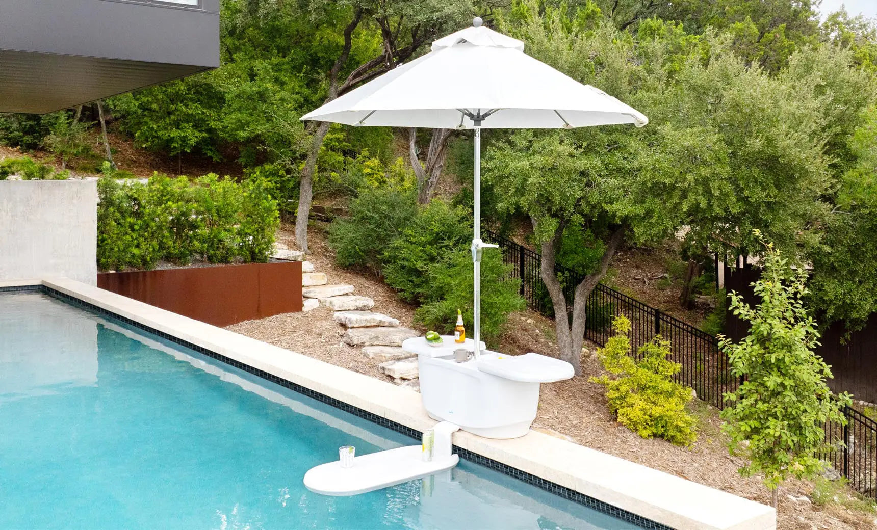 PartyPad swim-up bar with blue and white umbrella, ice bucket, and drinks on a pool deck.