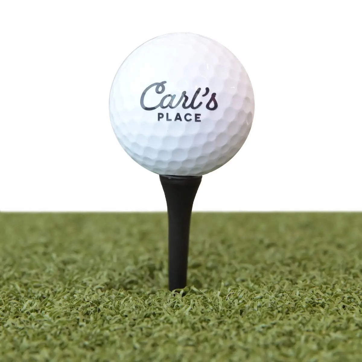 Carl's Place golf tees inserted into hitting mat showing proper ball height for simulator practice