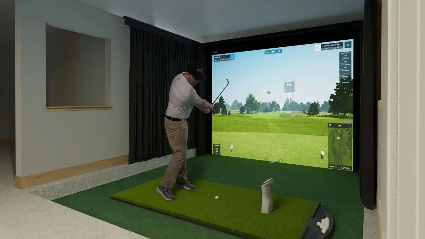 Person playing golf simulation game in a home setting with a screen displaying a virtual golf course.