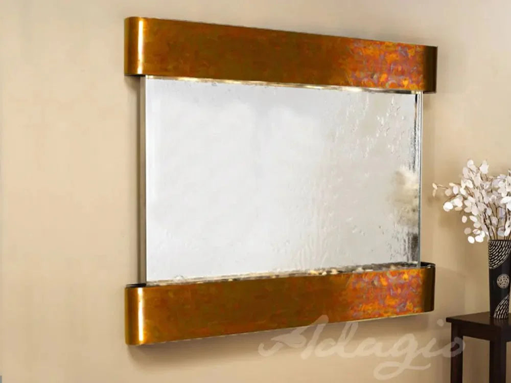 Decorative wall mirror with gold frame on a beige wall, brand 'Adagio' visible.