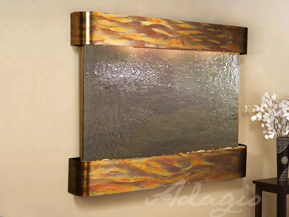 Decorative wall fountain with metallic design on a beige wall, featuring the brand 'Adelajdo'.
