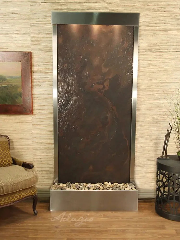 Decorative wall fountain with textured metal finish in a room setting.