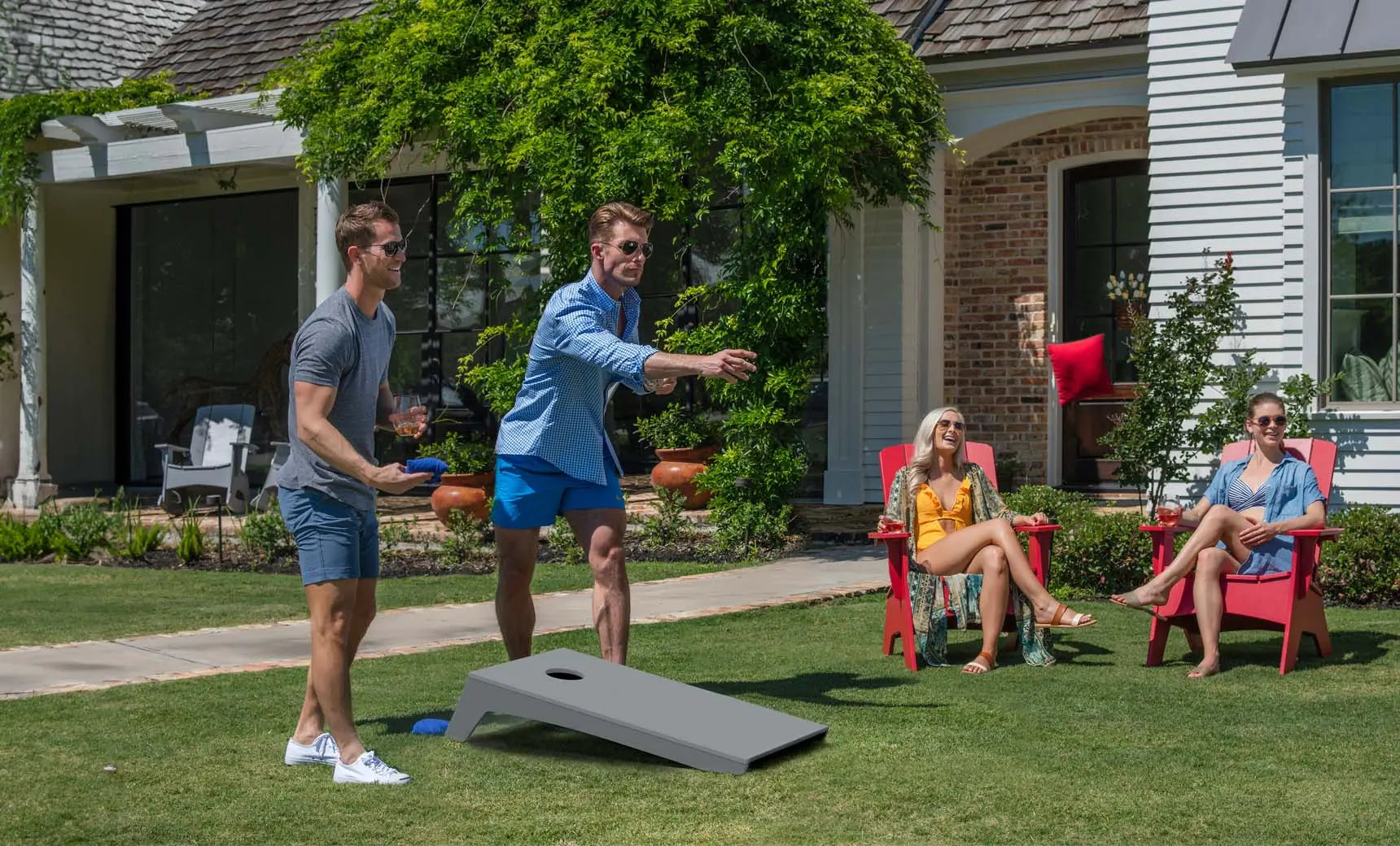 Cornhole board with red and black bags and game pieces placed nearby.