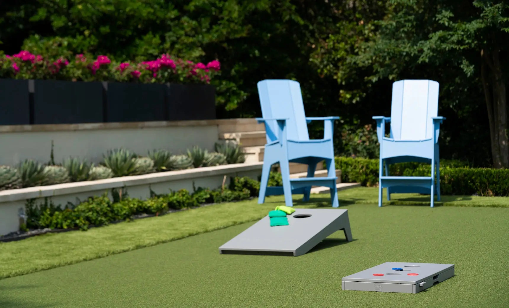 Cornhole board with red and black bags and game pieces placed nearby.