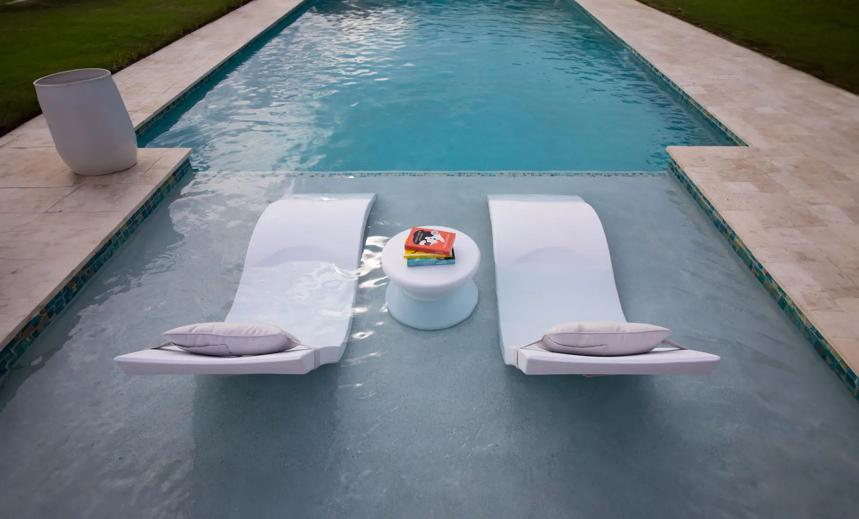 Signature chaise headrest pillow paired with a side table for in-pool use.