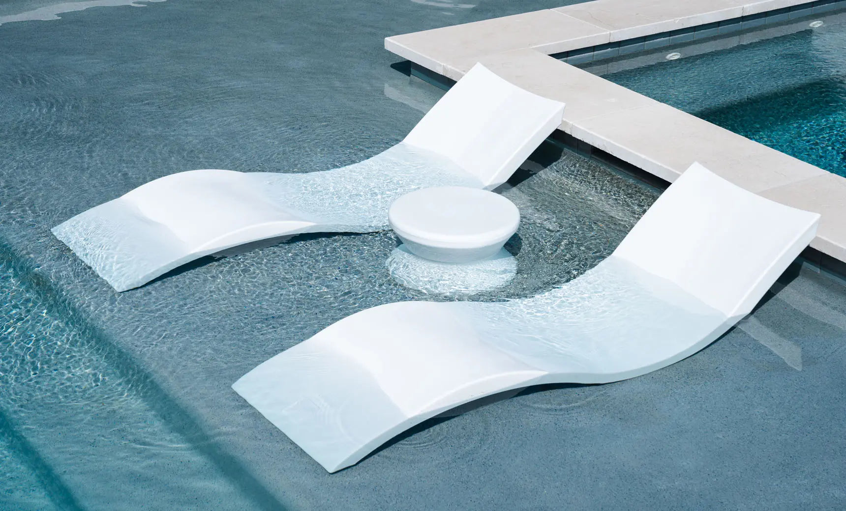 Signature chaise lounge in a modern design paired with a sleek side table for an in-pool setup.