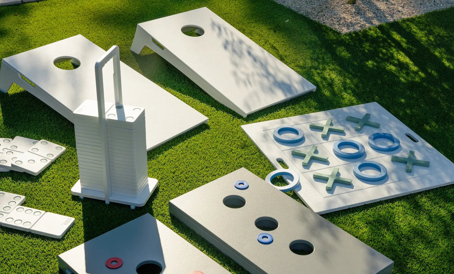Cornhole board with red and black bags and game pieces next to it.