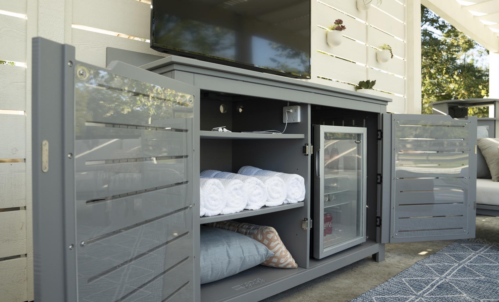 Mainstay bar credenza with wooden finish, glass doors, and interior shelving.