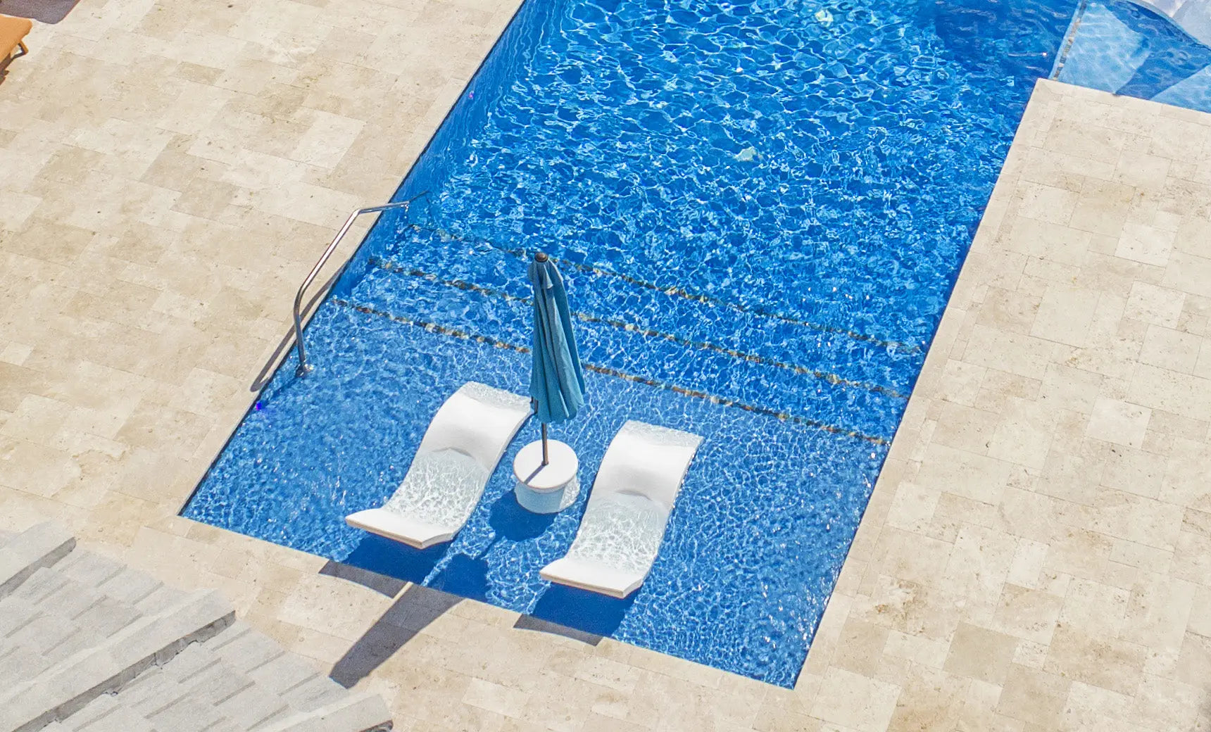 Signature chaise lounge in a modern design paired with a sleek side table for an in-pool setup.