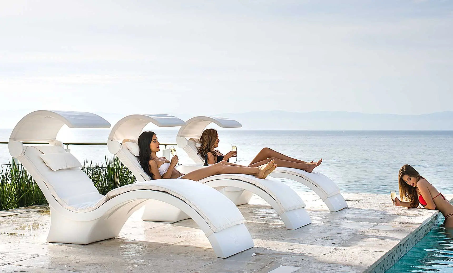 Signature chaise lounge with a brown fabric cushion and wooden frame, providing shade with its canopy.