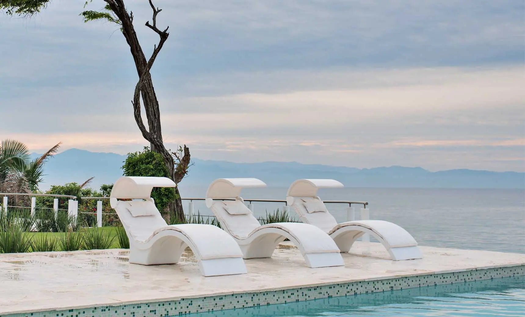 Signature Chaise deep reclining lounge chair in dark fabric with wooden frame and footrest.
