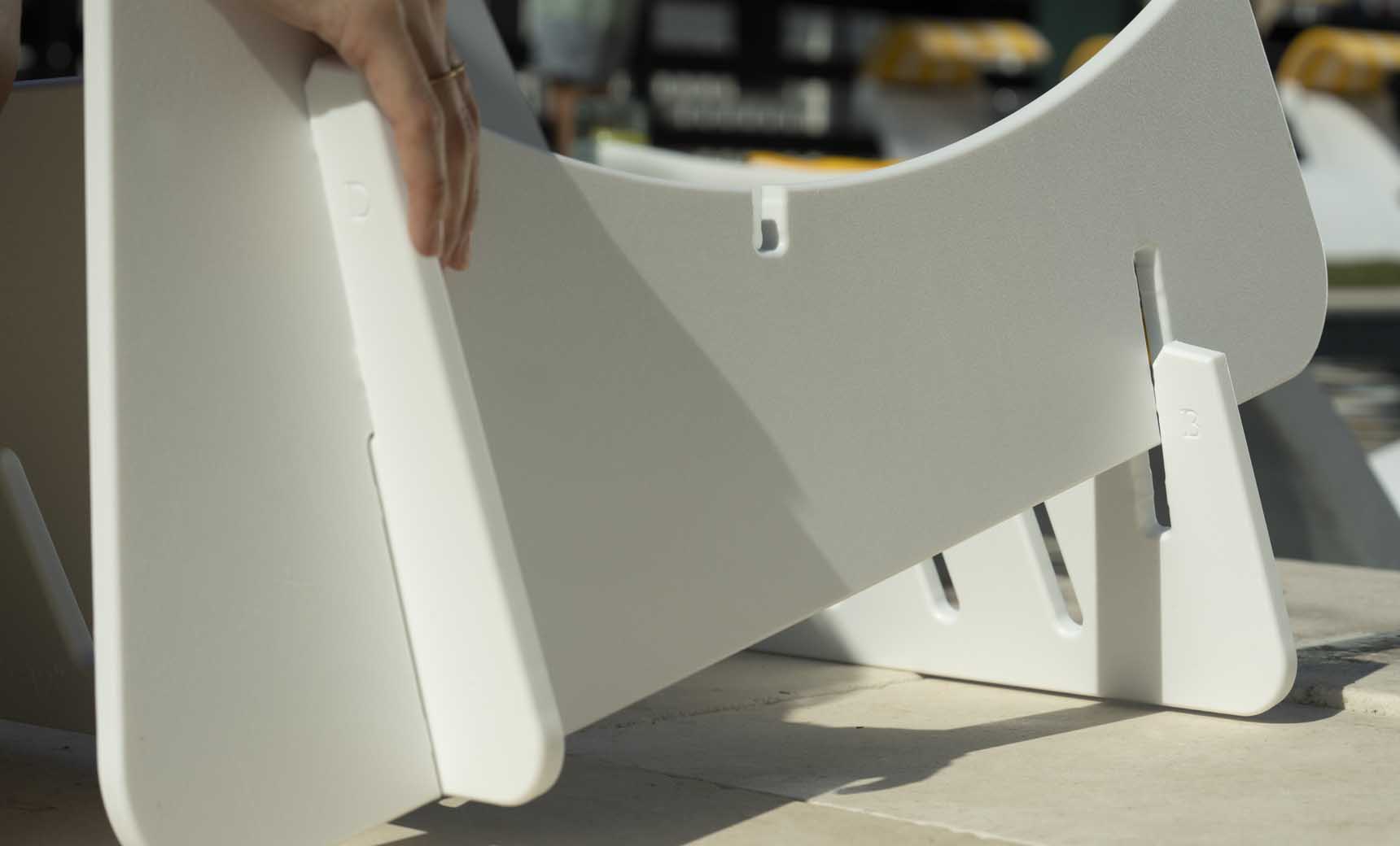 Signature Lowback chair elevated on a wooden riser with armrests and back support.