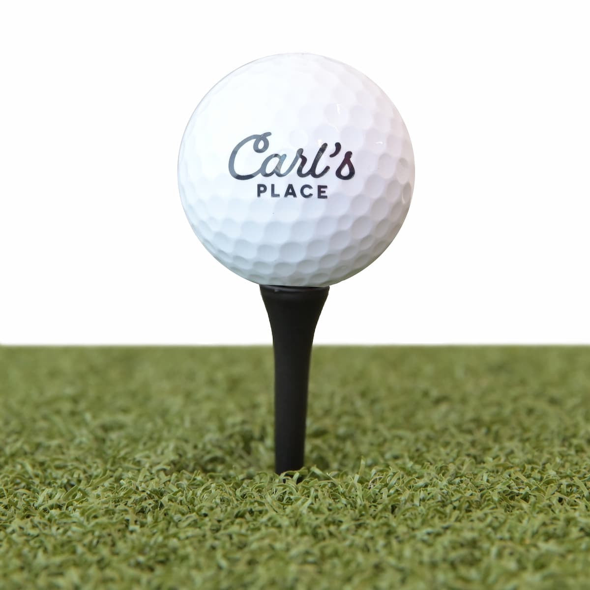 Carl's Place golf tees inserted into hitting mat showing proper ball height for simulator practice